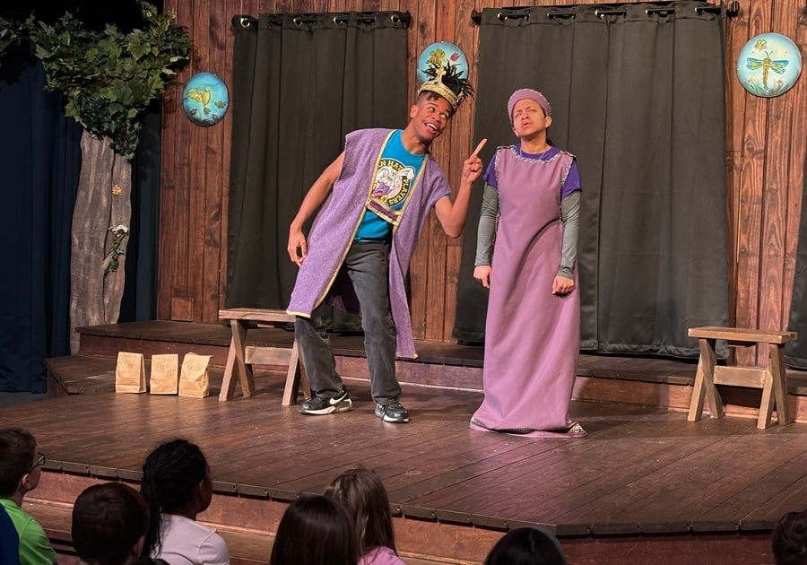 Two actors from Gamut Theatre’s The Golden Goose perform a hilarious scene on stage, engaging the young audience with humor and interactive storytelling.