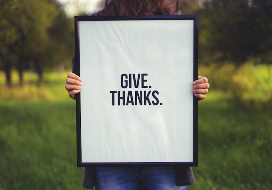 person holding give thanks sign