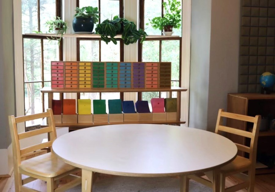 Photo of wooden table and rainbow-colored drawers on shelves