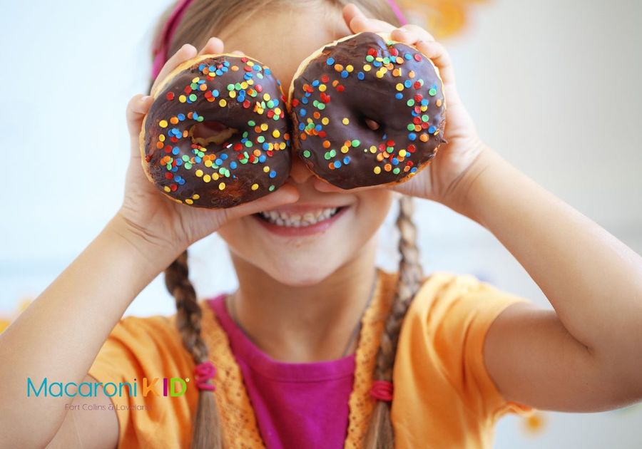 Girl with donuts over eyes national donut day