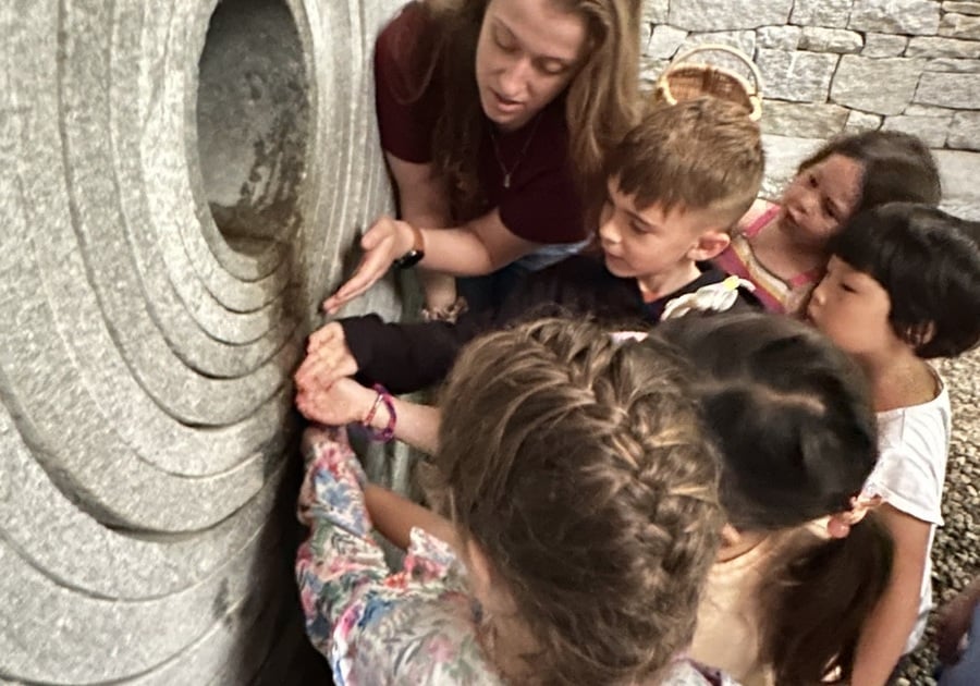 Children touching a sculpture