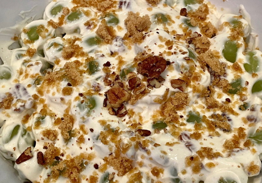 Green grapes mixed with cream cheese and walnuts, topped with sprinkled brown sugar