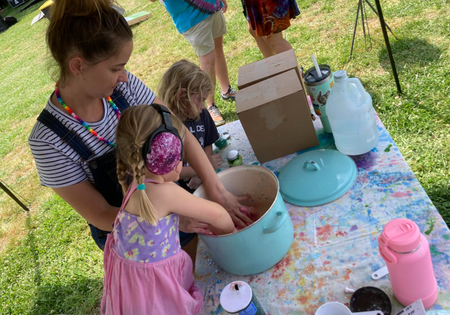 Photo of Ms. Alyssa making play dough outside with children