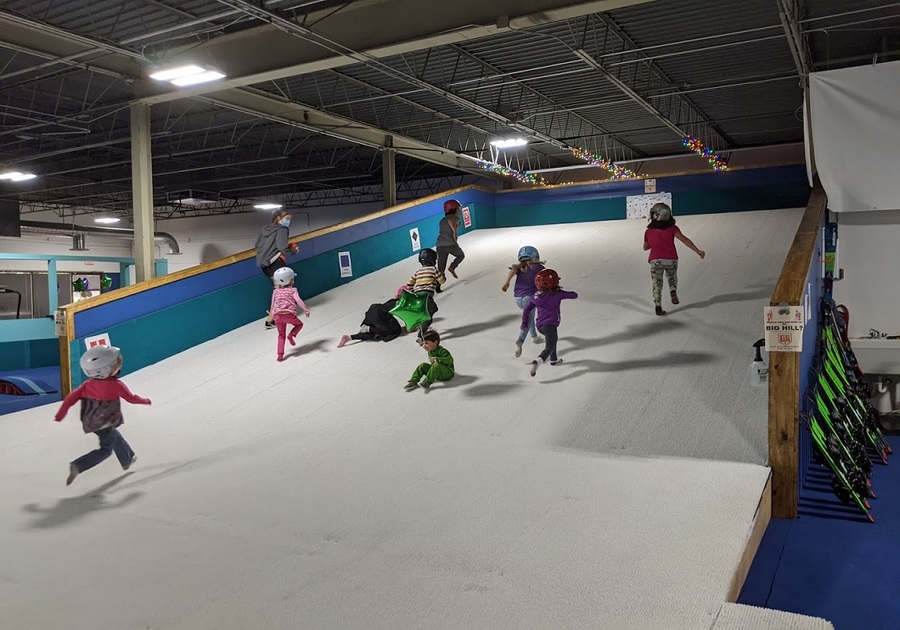 kids running up indoor artificial ski hill
