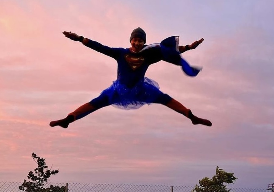 person in super man costume on trampoline