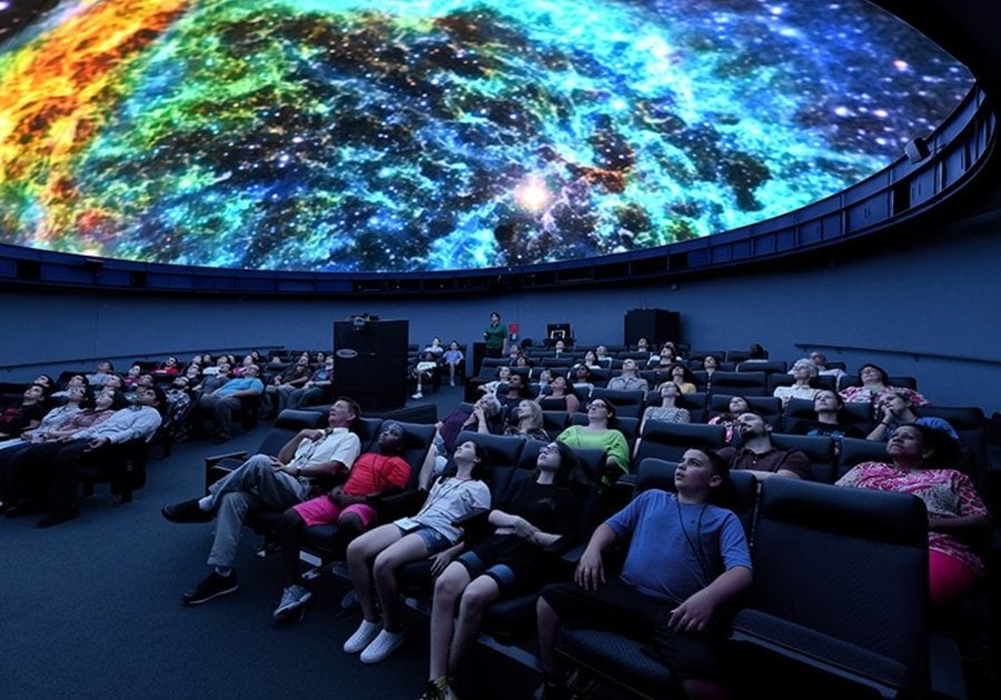 Audience viewing a galaxy in a planetarium