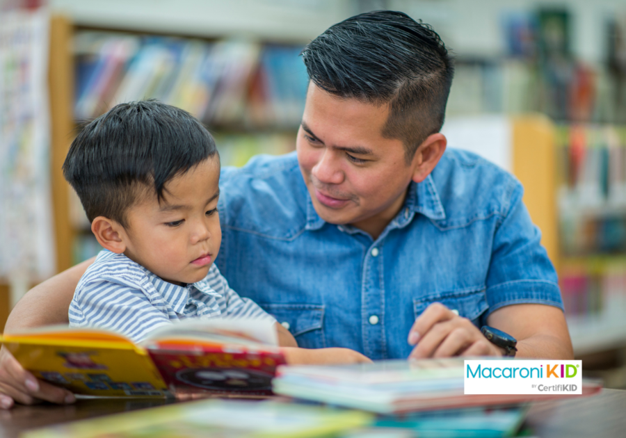 dad and child reading books at library