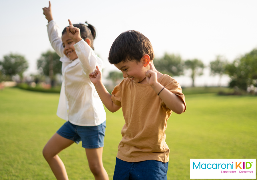 Happy children dancing together in a park