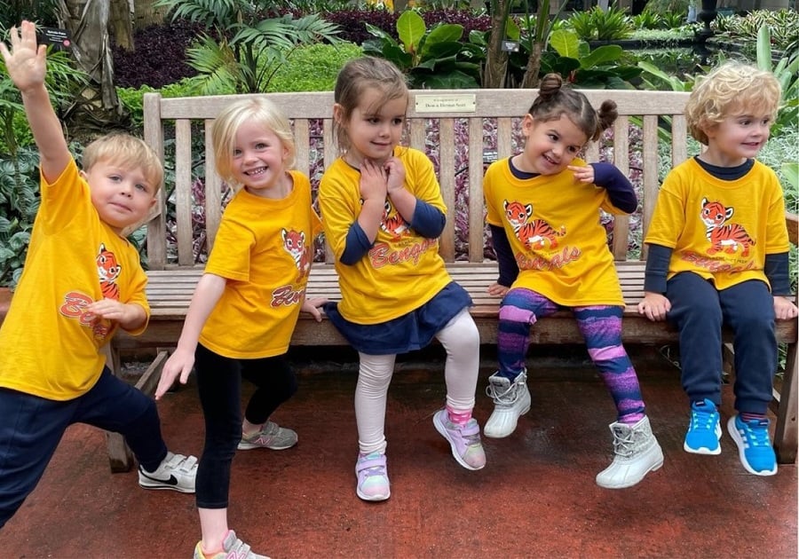 5 preschool kids all in the same yellow shirt on bench