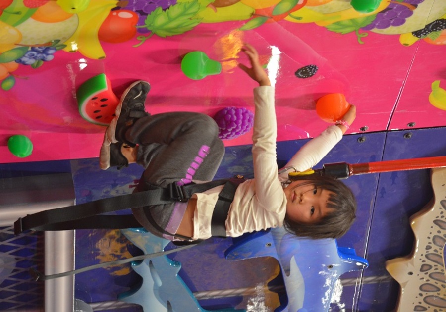 girl on colorful climbing wall