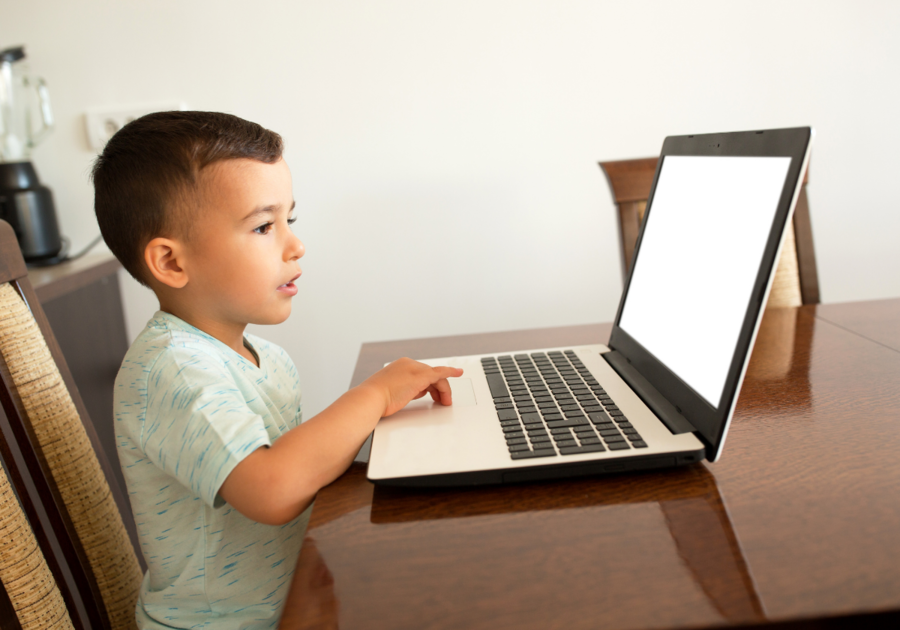 Young boy navigating a touch pad of a laptop