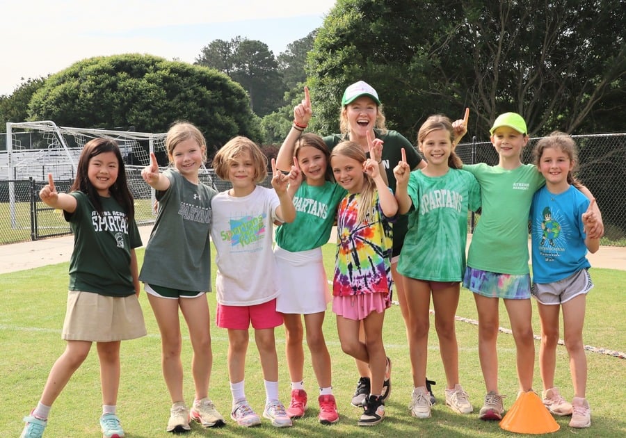 photo of a group of female campers outside on soccer field