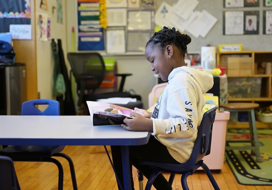 girl reading book at desk