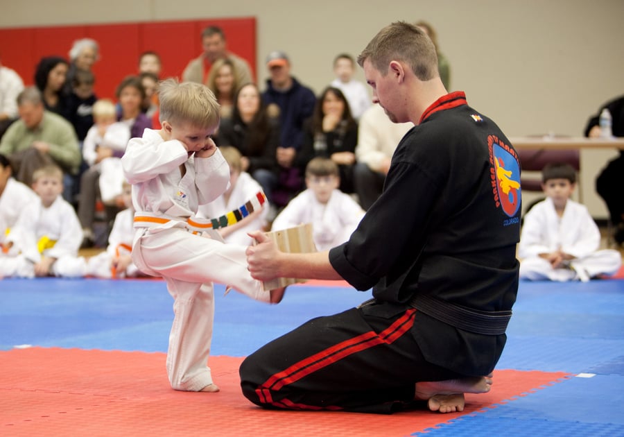 very young child trying to break a board with a martial arts kick