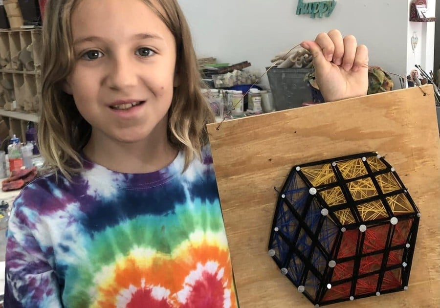 girl holding up wood project