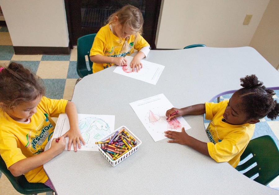 Campers coloring at a table