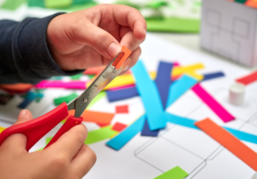 child cutting paper with scissors