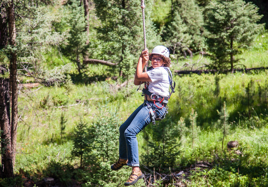 on a rope swing at Girl Scouts of Colorado summer camp