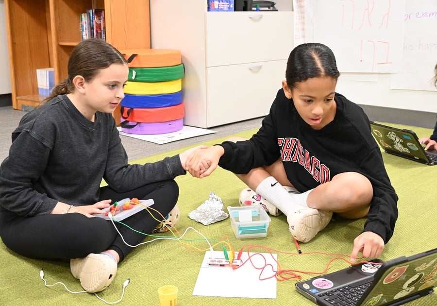 two girls working on a laptop