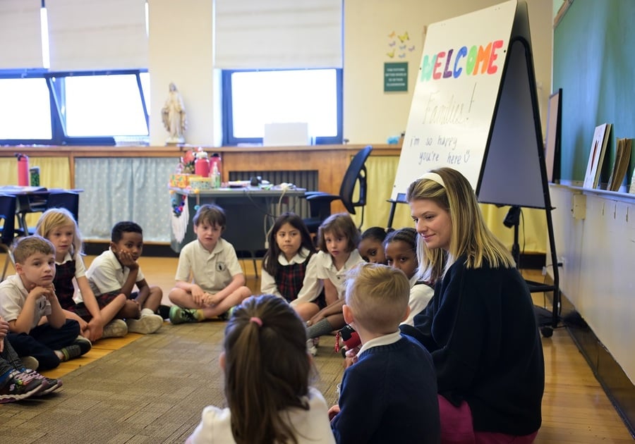 students sitting in circle on floor in classroom