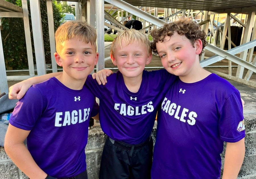 Children standing together outside of sports bleachers