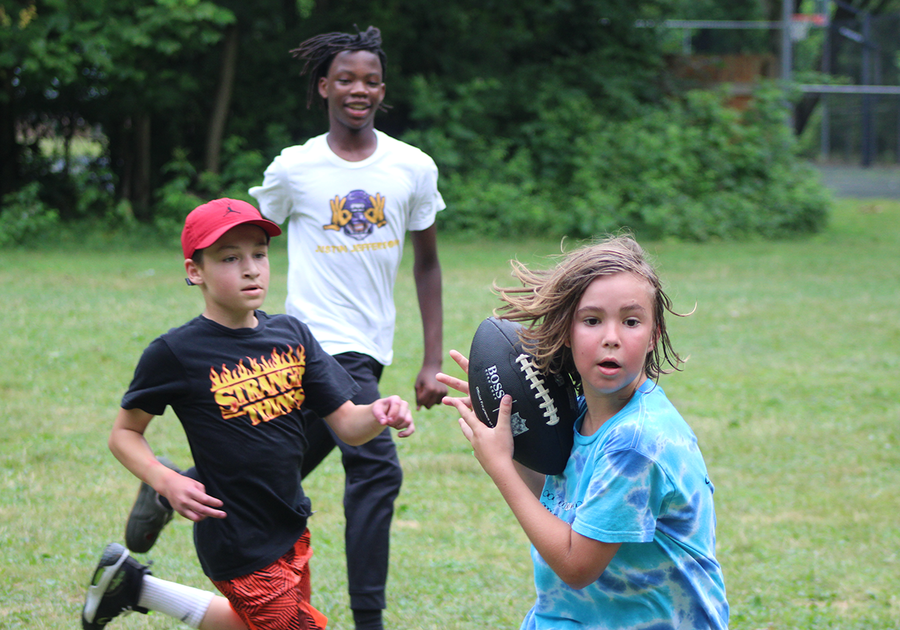 three kids playing football