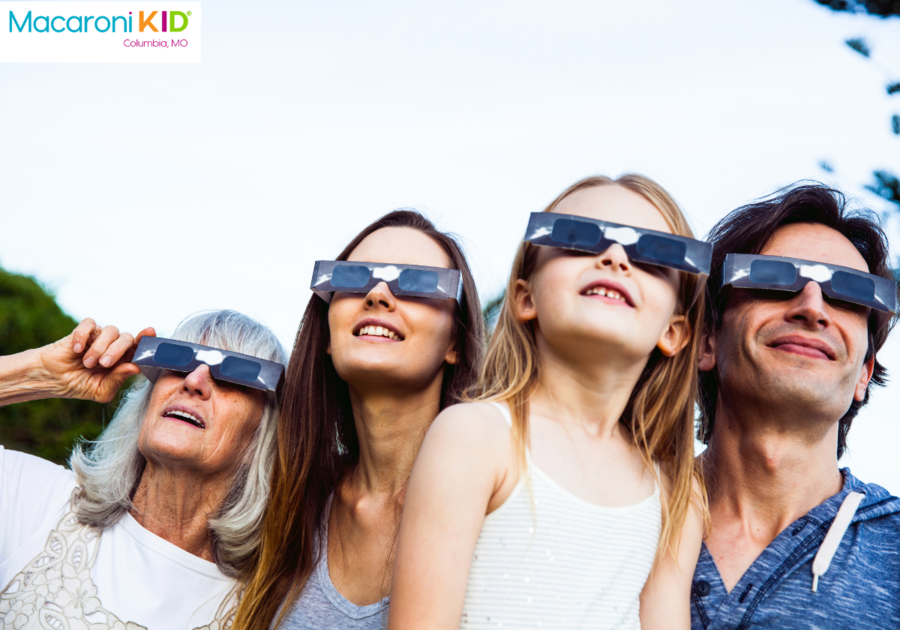 family looking at solar eclipse through glasses