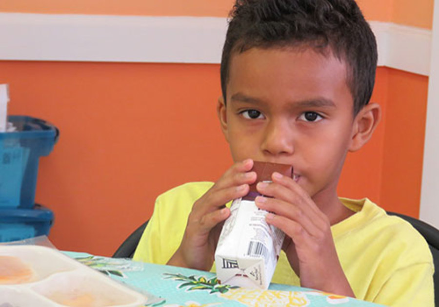 Child enjoying meal during Treasure Coast Food Bank's 2018 Summer Meals program