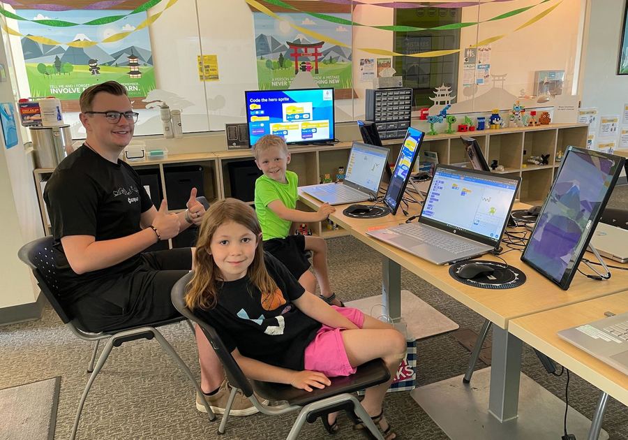 two kids and an instructor at laptops at Code Ninjas Parker