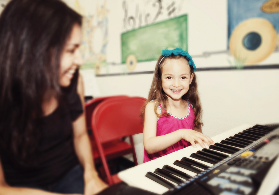 child learning to play keyboard at Children's Music Academy class