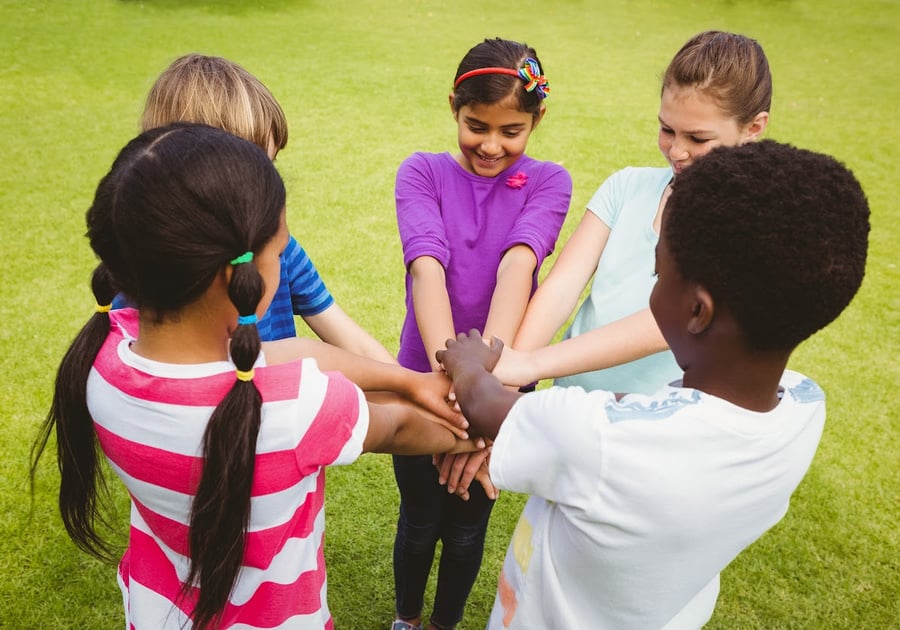 children of various ethnicities holding hands in a circle