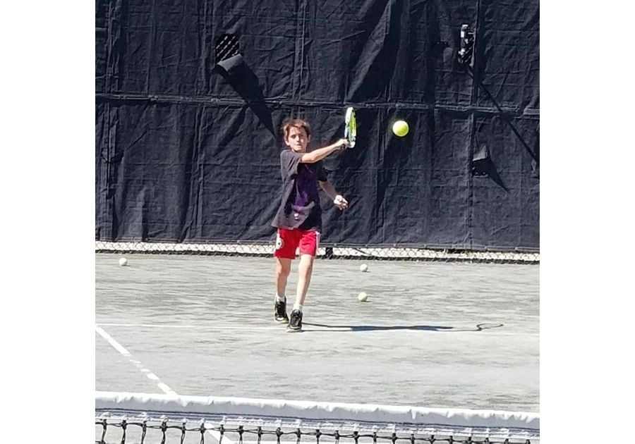 boy hitting tennis ball