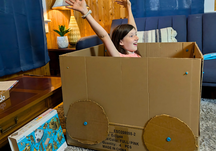 Girl is excited after creating a four person car with Makedo tools