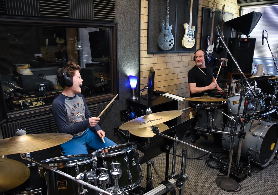 happy student and instructor playing drums togehter at Colorado Music Institute