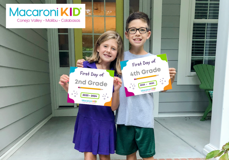 Young boy and girl in front of their home holding First Day of school signs
