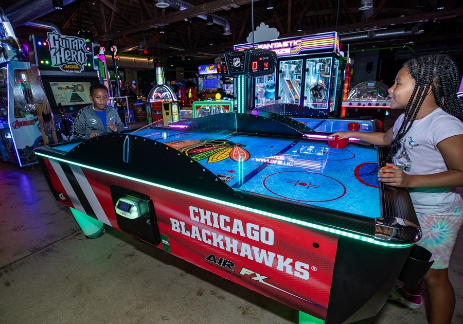 2 kids playing air hockey in arcade