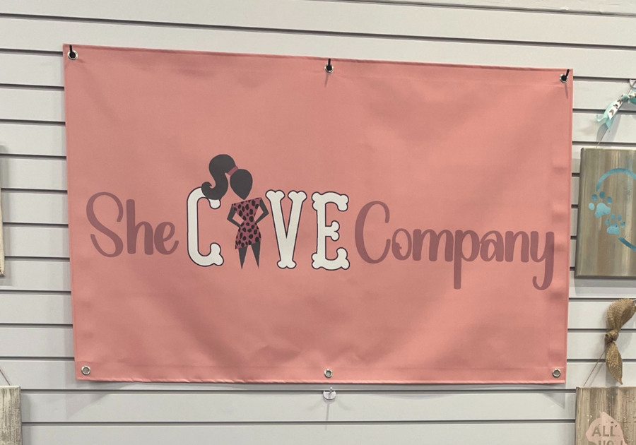 Pink banner with company name She Cave on it