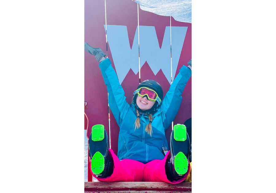 girl sitting in adirondack chair at ski slope