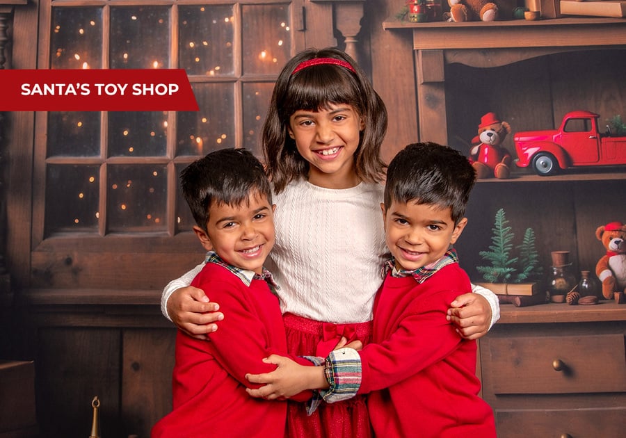 Kids with Santa in festive toy shop setting, holiday photo session at JCPenney Portraits