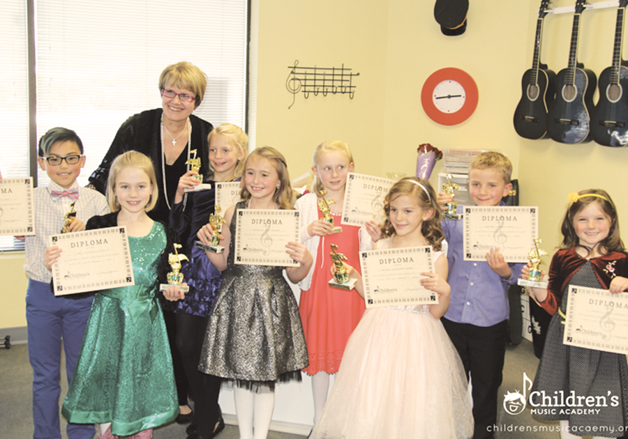 children holding certificates of completion for Children's Music Academy