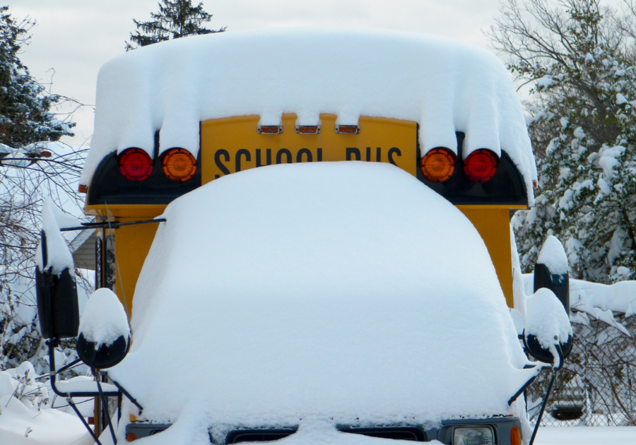 Yellow school bus covered with fresh snow