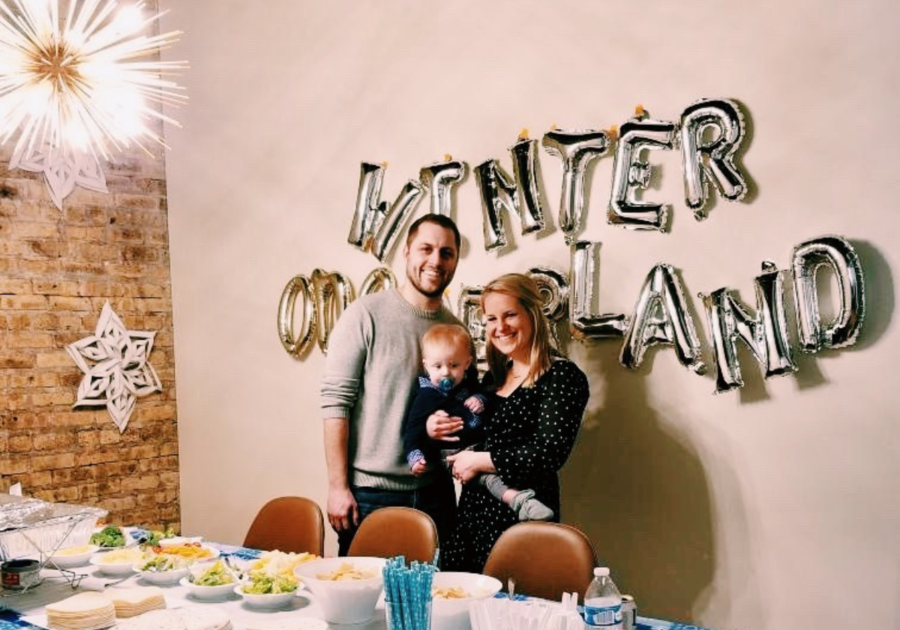 two parents and baby at party table