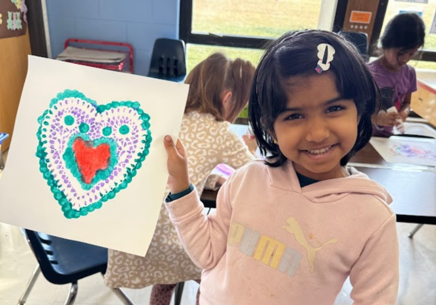 preschooler holding their painting of a heart