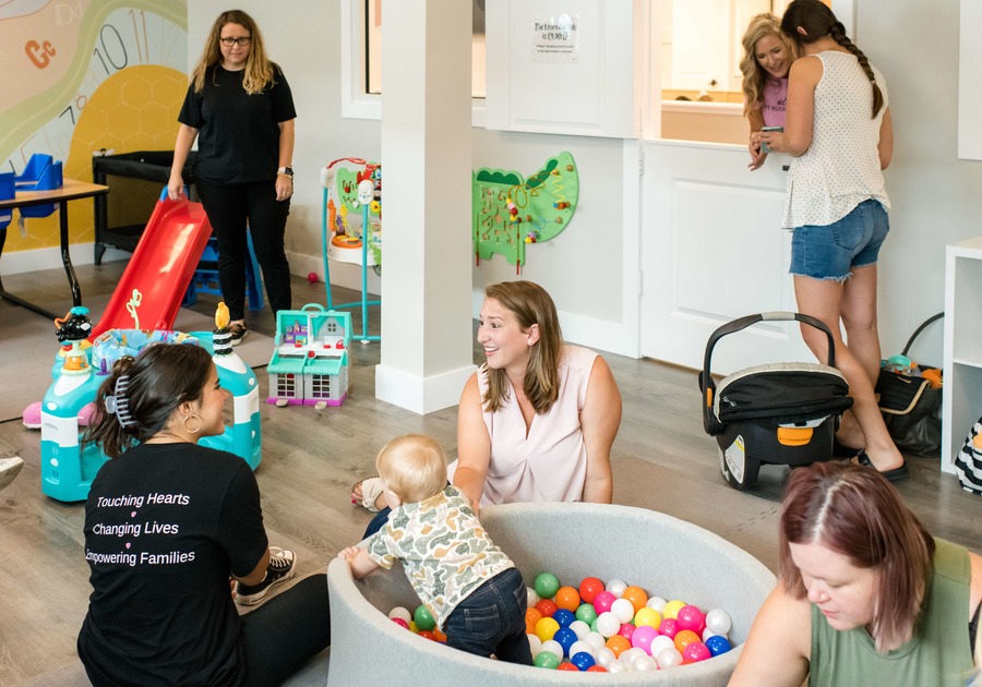 Workers, moms, kids playing in learning lab