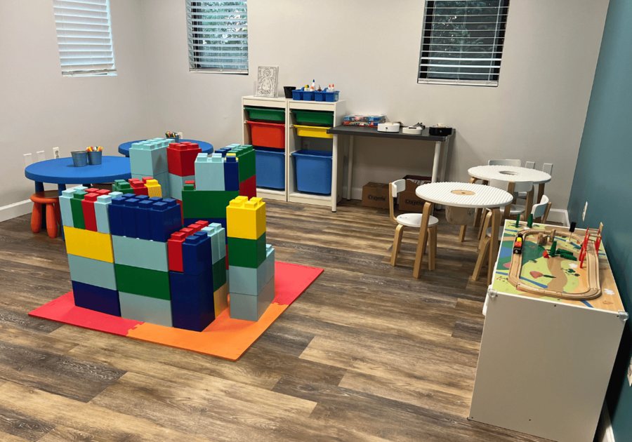 NEW Craft room with large LEGO blocks; tables; toy train track; windows.