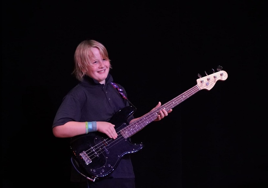 tween boy playing guitar on stage