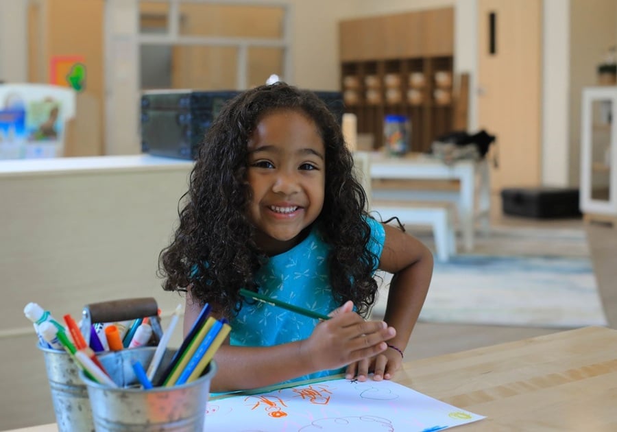 little girl painting and smiling