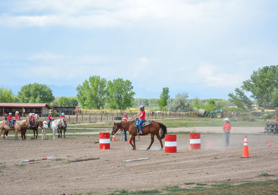 child on horseback learning riding skills in the arena at Big Horn Stables summer camp