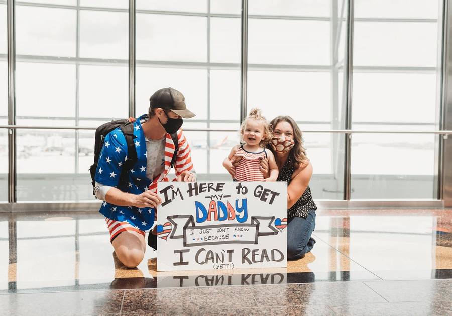 publisher and family at airport with welcome home sign