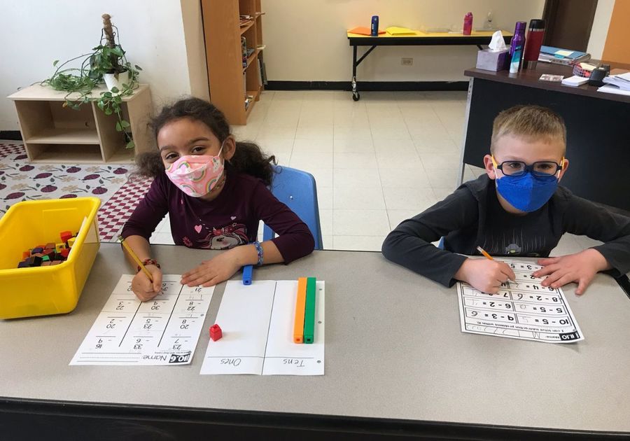 a boy and girl in class with masks on